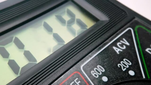 close-up of measuring voltage with a digital multimeter. close-up of the multimeter screen with measurement data.