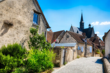 Street in the Beautiful Village of Montresor, Loire, France, with St John the Baptist Collegiate Church - obrazy, fototapety, plakaty