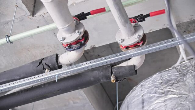 Metal pipes with flanges and levers of fire suppression system under ceiling in room low angle shot. Building safety