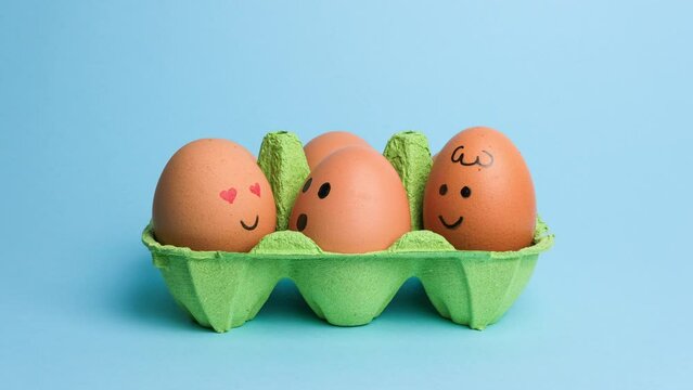 Cute easter eggs with funny faces in green box isolated on blue background. Happy easter concept. Stop motion easter animation.