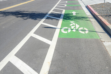 Bicycle lane marked in green along a road in a business park on a sunny day