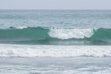 Seascape. View of the waves and surf. Windy weather. Waves, foam and ripples on the surface of sea water. Summer landscape. The expanses of the Pacific Ocean. Beautiful natural background. Nobody.