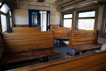 Naklejka premium Old empty wagon of train. Wooden seats in an empty coach of train