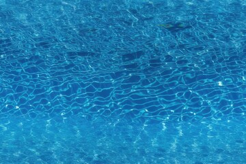 Obraz premium Blue water surface of a swimming pool with strong sun light reflections. Generative AI