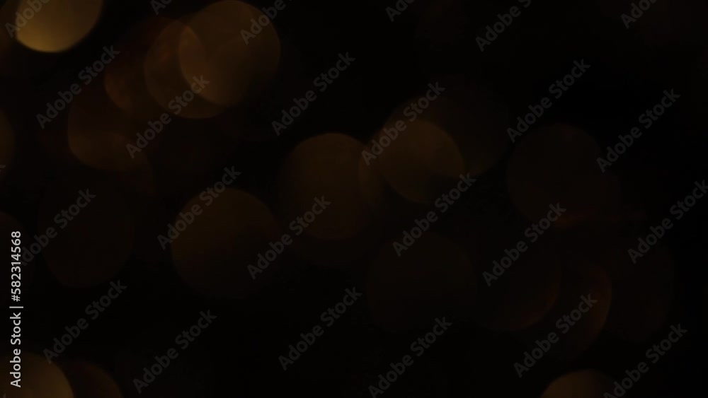 Canvas Prints smooth motion of gold sepia bokeh on black background. horizontal appear and disappear of defocused 