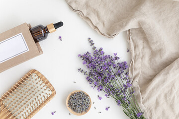 Amber bottle of lavender essential oil. Flat lay concept skin care. Light background with lavend flower. - obrazy, fototapety, plakaty
