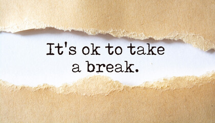 It's ok to take a break. Words written under torn paper. Motivation concept text.