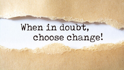 When in doubt, choose change. Words written under torn paper. Motivation concept text.