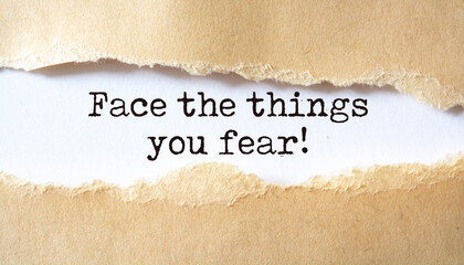 Face the things you fear. Words written under torn paper. Motivation concept text.