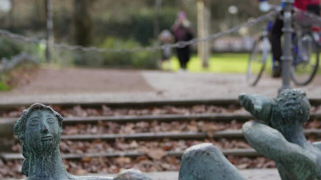 Statue in park in Frankfurt and People