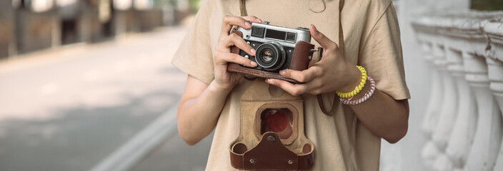 woman holding vintage camera in street
