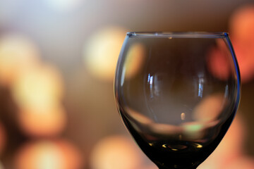 Horizontal close up of glass cup of wine empty with copy space in lights bokeh background