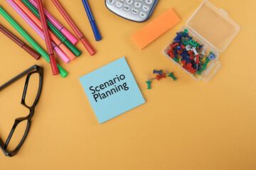 Scenario Planning concept with a message written on the blue post-it note on the yellow background. View from the top, flat lay.