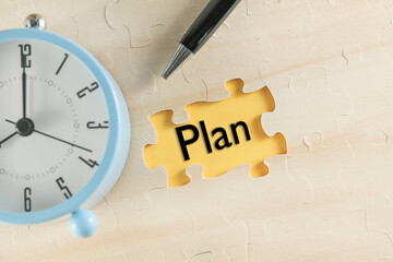 A message on PLAN is written on a yellow background. An alarm clock at the side