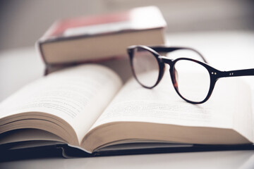 open book with eyeglasses set on it