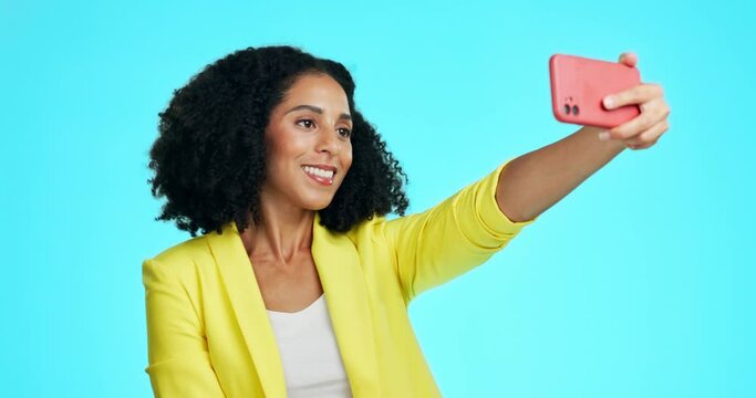 Kiss, peace sign and selfie of woman in studio isolated on a blue background. Air kissing, v hand emoji and smile of young female taking pictures for happy memory, profile picture or social media.