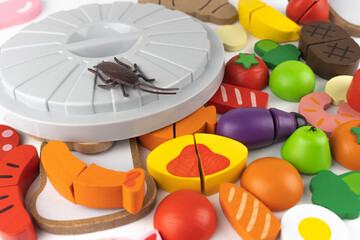 木の玩具の食品とゴキブリとゴミ箱の蓋。害虫発生のイメージ