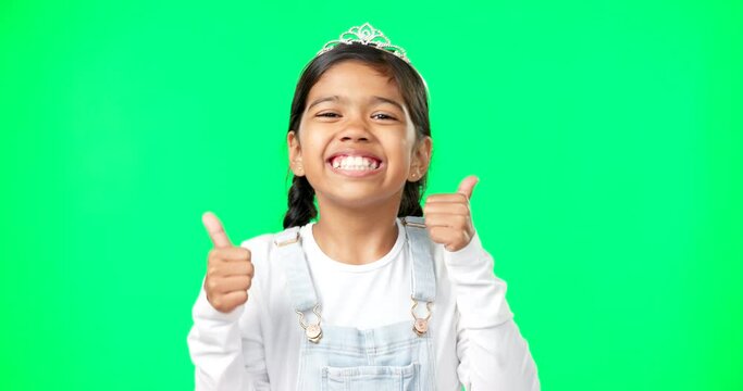 Portrait, children and thumbs up with a girl on a green screen background in studio wearing a princess tiara. Kids, thank you and emoji with an adorable little girl child saying yes in agreement