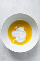 Melted butter and white sugar in a white bowl