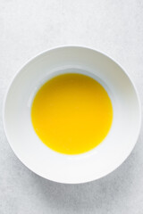 Melted butter in a white bowl, liquid butter, melted butter for baking in a mixing bowl 