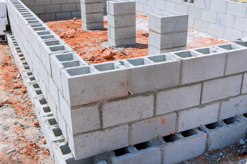 It is common for cement blocks be laid for walls that will attached to house foundation during...