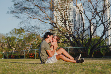 *"Father kissing his 6-month-old baby on grassy park with city skyline backdrop"*

