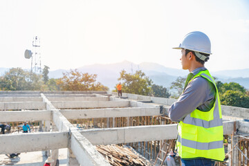 Professional Worker Wearing Safety Vest and Hard Hat Charmingly Looks Into the Distance.