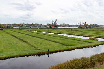 Beautiful Zaanse Schans Windmill Landscape on a Cloudy Autumn Day with a Canal in the Netherlands