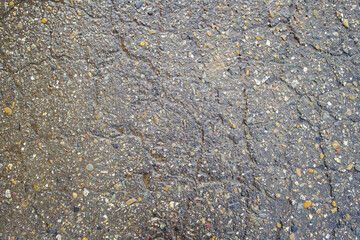 Old road background surface of gray cracked asphalt texture closeup. Old cracked asphalt. Grunge...