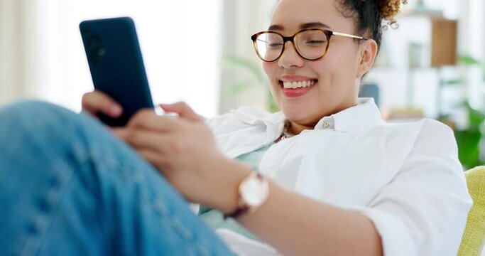 Happy woman relax on sofa and phone for internet, social media post or texting on mobile app at home. Young biracial person on couch or lounge scroll and typing on a cellphone, smartphone or web chat