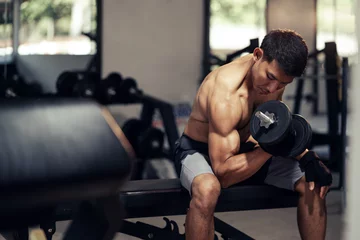 Fotobehang Sportschool Asian man shirtless workout weight training biceps muscles with dumbbell in fitness gym. Weight training exercise in concept of health and wellness.  © ME Image