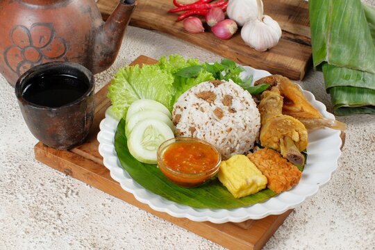 Nasi Tutug Oncom. Traditional Sundanese meal of rice mixed with fermented soybean; accompanied with grilled prawn, tempeh, tofu, salted fish, vegetables and chili paste
