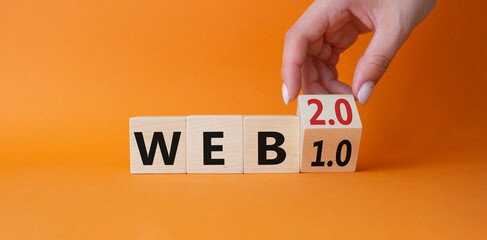 WEB 2 or 1 symbol. Businessman hand Turnes cube and changes word WEB 1.0 to WEB 2.0. Beautiful orange background. Business and WEB concept. Copy space