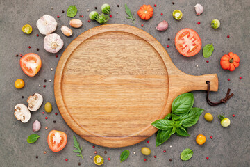 The ingredients for homemade pizza set up on dark stone background.