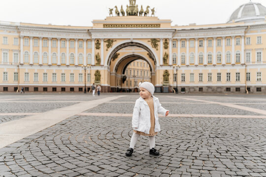 Little stylish fashionable toddler girl on the Palace Square in Russia