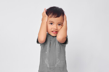 Unhappy toddler Asian muslim boy holding hand in head isolated on white studio background