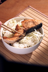 Japanese bowl of rice and salmon with chopsticks