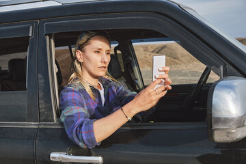 Woman taking a picture of Grand Canyon through the car window