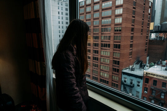 Woman Looking At City Out Of Window