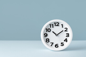 Plain wall clock on pastel gray background desk. Ten o'clock. copy space, time management or...