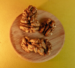 Greek nuts without shell on a wooden board yellow background