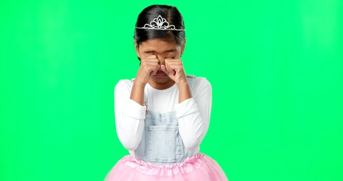 Sad, depression and child crying on green screen with crown, princess costume and tutu in studio. Sadness mockup, tears and isolated young girl with worried, upset and disappointed facial expression