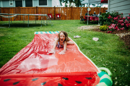 Young girl playing on slip and slide