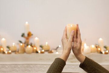Kobieta modli się trzymając w dłoniach zapaloną świecę. Zmartwychwstanie pańskie wiara i...