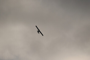 Small plane flying in the sky against dark clouds