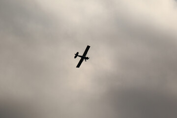 Small plane flying in the sky against dark clouds