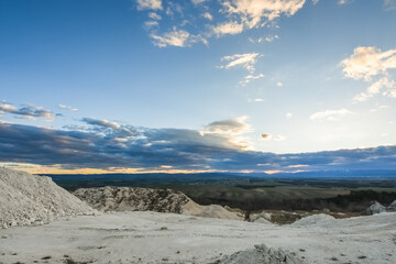 landscape with a lime quarry and colorful clouds during sundown