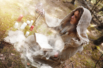 A man in a cassock spends a ritual in a dark forest