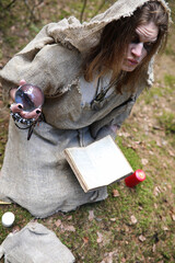 A man in a cassock spends a ritual in a dark forest