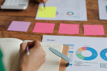 Teamwork with businessman analyzing cost graphs on table at conference room.